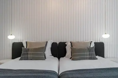 two beds in a room with striped walls at Savoy Insular V by An Island Apart in Funchal