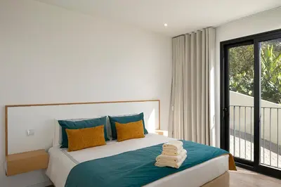 a bedroom with a large bed with towels on it at Marco 4 Seasons- Spring in Arco da Calheta