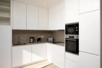 a white kitchen with white cabinets and appliances at Marco 4 Seasons- Spring in Arco da Calheta
