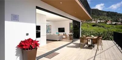 a patio with a table and chairs and a couch at Marco 4 Seasons- Spring in Arco da Calheta