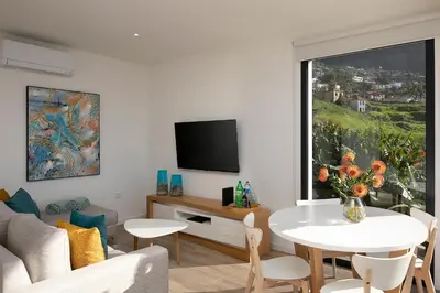 a living room with a table and a large window at Marco 4 Seasons- Spring in Arco da Calheta