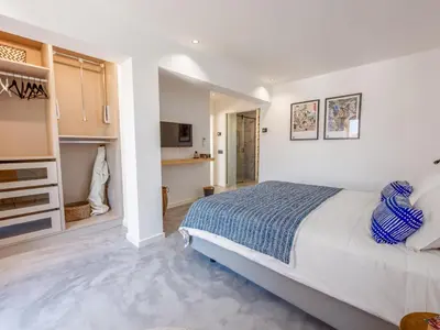 a bedroom with a large bed and a kitchen at Baía Beach Apartment in Luz