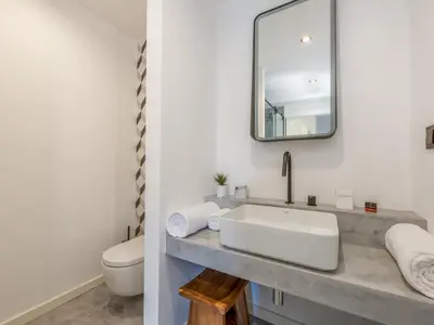 a white bathroom with a sink and a toilet at Baía Beach Apartment in Luz