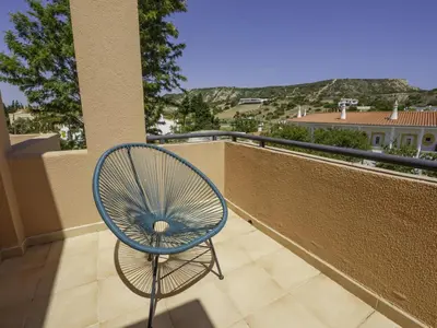 a blue chair sitting on a balcony with a view at Baía Beach Apartment in Luz
