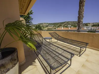 a group of chairs on a balcony with a plant at Baía Beach Apartment in Luz