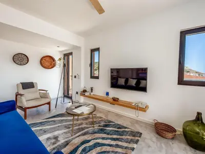 a living room with a blue couch and a tv at Baía Beach Apartment in Luz