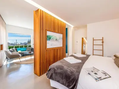 a bedroom with a large bed and a living room at Apt. Rocha N. in Lagos
