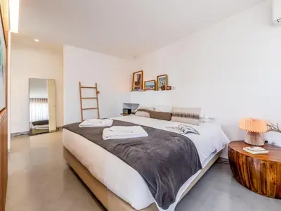 a bedroom with a large bed and a wooden table at Apt. Rocha N. in Lagos