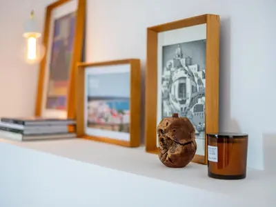 a vase sitting on a shelf next to framed pictures at Apt. Rocha N. in Lagos