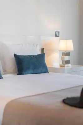 a bed with a blue pillow and a lamp at Madalenas II by An Island Apart in Funchal