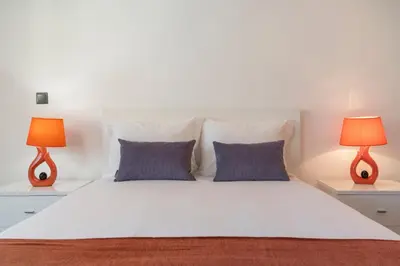 a bedroom with a large white bed with two lamps at Madalenas II by An Island Apart in Funchal