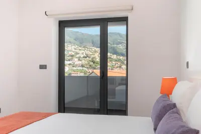 a bedroom with a bed and a view of a city at Madalenas II by An Island Apart in Funchal