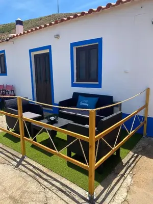 a porch with a couch on the side of a house at Casa Rochinha in Aljezur