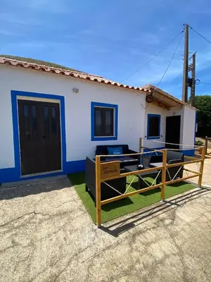 a small white and blue house with a wooden fence at Casa Rochinha in Aljezur