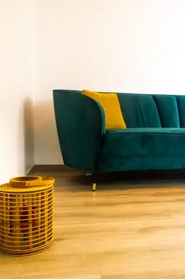 a green couch with a yellow pillow and a basket at Faria House by Horizon View Madeira in Funchal