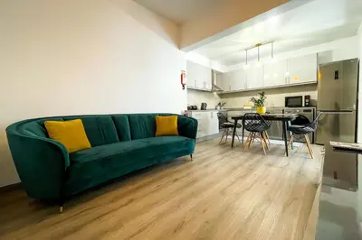 a living room with a green couch and a kitchen at Faria House by Horizon View Madeira in Funchal