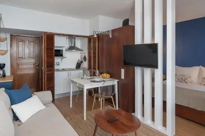 a living room with a small table and a room with a bed at Incredible sea view Apartamento do Mar I in Funchal