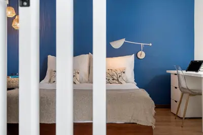 a bedroom with blue walls and a bed with a desk at Incredible sea view Apartamento do Mar I in Funchal