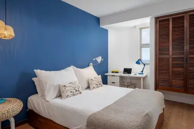a blue bedroom with a large bed with white pillows at Incredible sea view Apartamento do Mar I in Funchal