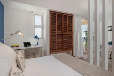 a bedroom with a bed and a desk and a window at Incredible sea view Apartamento do Mar I in Funchal