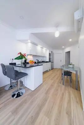 a kitchen with white cabinets and a stainless steel refrigerator at Debbie & Cris House by Mth in Machico