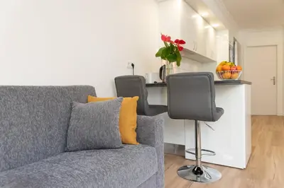 a vase with a bowl of fruit on a table with a clock at Debbie & Cris House by Mth in Machico