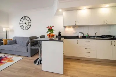 a kitchen and a living room with a couch at Debbie & Cris House by Mth in Machico