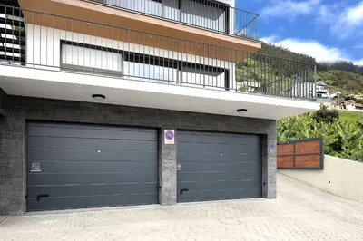 two garage doors in front of a building at Marco 4 Seasons- Summer in Arco da Calheta