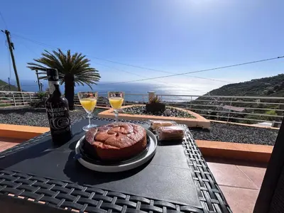 a table with a cake and two glasses of wine at Vila Mendes - Ocean View in Arco da Calheta