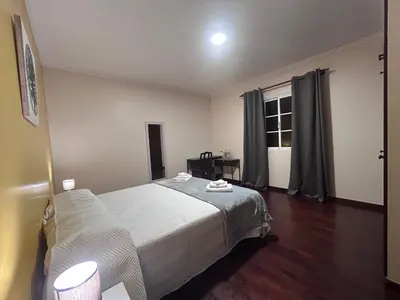 a bedroom with a large bed and a window at Vila Mendes - Ocean View in Arco da Calheta