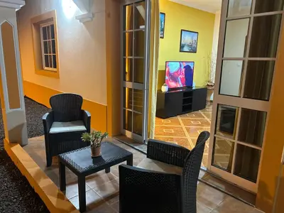 a living room with chairs and a table and a tv at Vila Mendes - Ocean View in Arco da Calheta