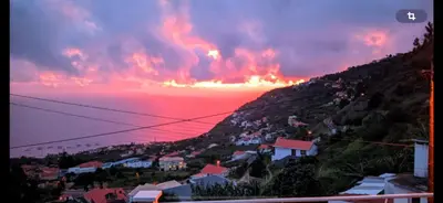 a view of a town on a hill at sunset at Vila Mendes - Ocean View in Arco da Calheta