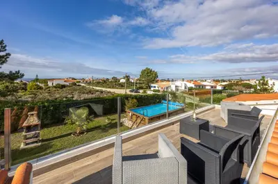 a balcony with patio furniture and a swimming pool at Casa Cool in Aljezur