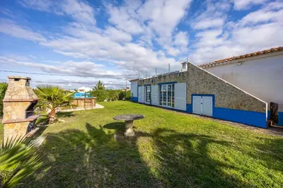 a house with a grass yard in front of a building at Casa Cool in Aljezur