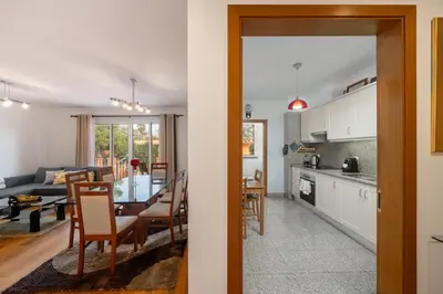 a kitchen and a living room with a table and chairs at Caniço Golden by An Island Apart in Caniço