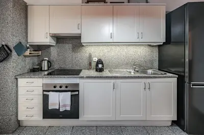 a kitchen with white cabinets and a sink at Caniço Golden by An Island Apart in Caniço
