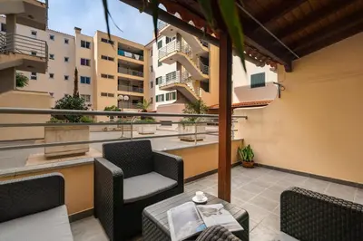 a balcony with chairs and a table and some buildings at Caniço Golden by An Island Apart in Caniço