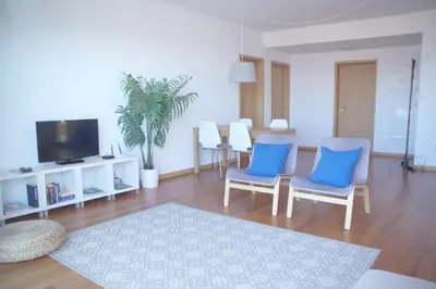 a living room with two blue chairs and a tv at Carvalhal Old Town in Funchal