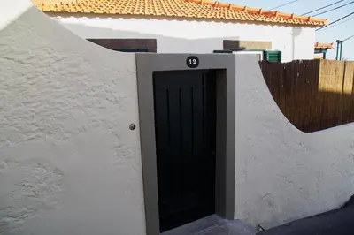 a black door in the side of a white building at Carvalhal Old Town in Funchal