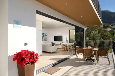 a patio with a table and chairs and a living room at Marco 4 Seasons- Winter in Arco da Calheta