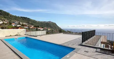 a swimming pool on a patio with a view of the ocean at Marco 4 Seasons- Winter in Arco da Calheta