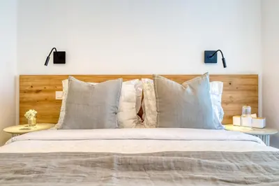 a bedroom with a bed with a wooden headboard and pillows at Funchal Acqua Blue 8E, a Home in Madeira in Funchal