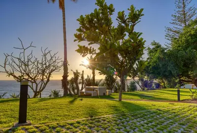 a park with a bench and the ocean in the background at Funchal Acqua Blue 8E, a Home in Madeira in Funchal
