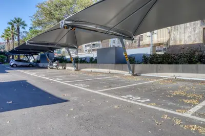 a parking lot with two large umbrellas in it at Funchal Acqua Blue 8E, a Home in Madeira in Funchal