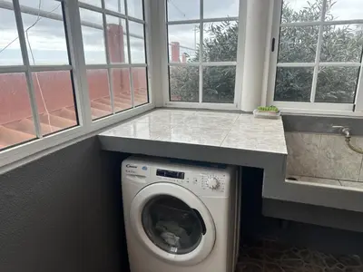 a washing machine in a laundry room with windows at Casa Mary Bela's in Ponta do Sol