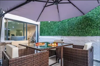 a table and chairs with an umbrella on a patio at Madeira House by Mathias in Funchal
