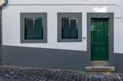 a building with two green doors and two windows at Madeira House by Mathias in Funchal