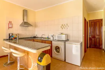 a kitchen with a sink and a washer and dryer at One Love Maktub in Paul do Mar