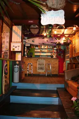 a restaurant with a bar in the middle of a room at One Love Maktub in Paul do Mar