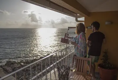 a man and woman standing on a balcony looking at the ocean at One Love Maktub in Paul do Mar